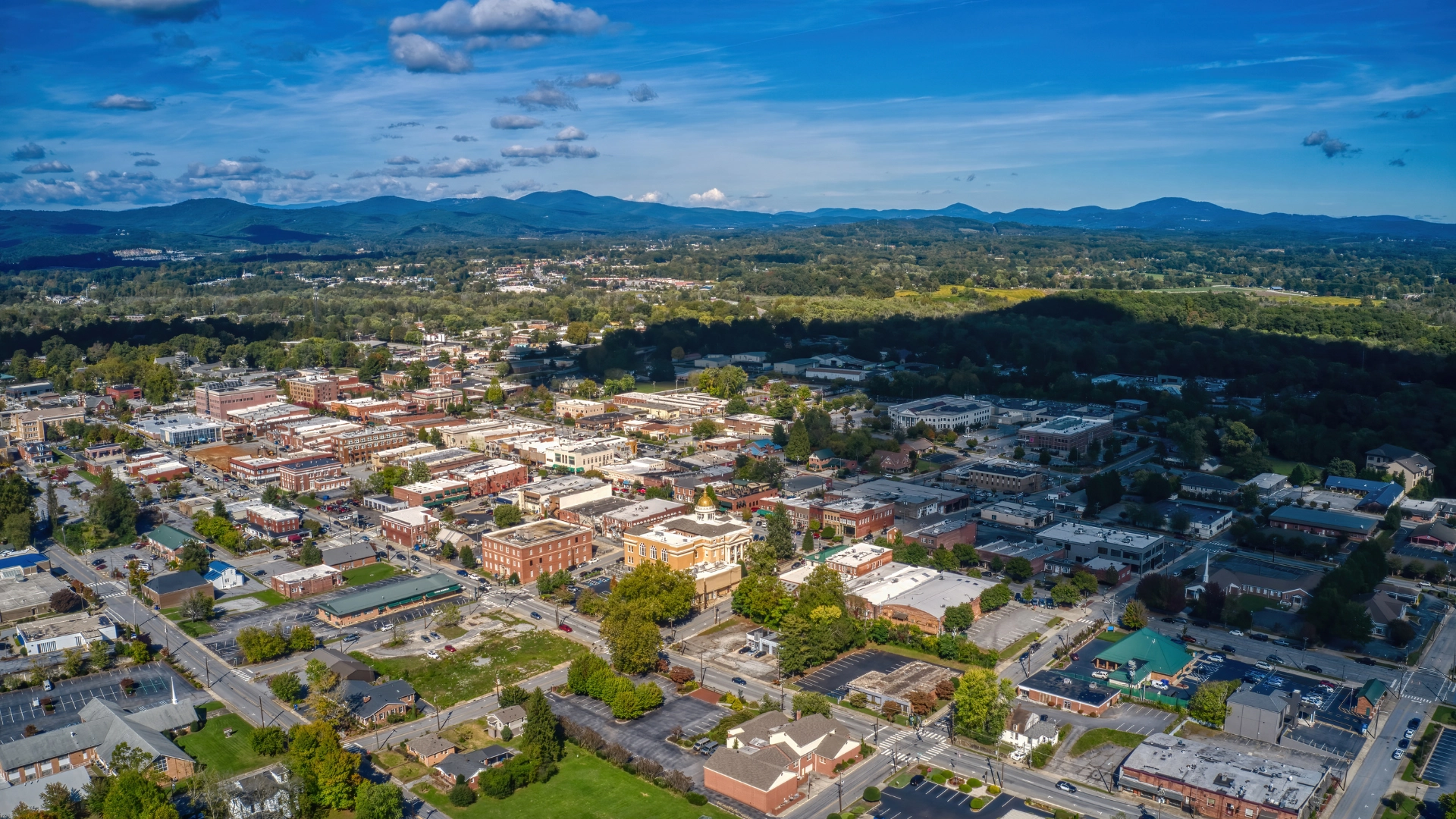 Aerial view of downtown Hendersonville, North Carolina with surrounding neighborhoods, commercial buildings, and mountain landscape, representing the local service area of Worx Property Services.